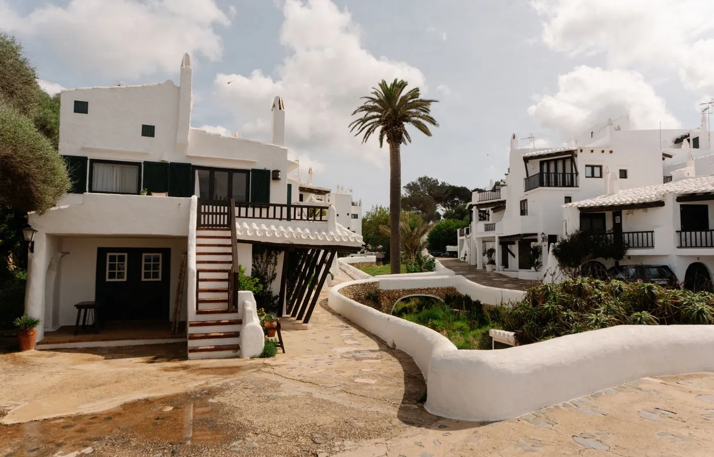Straße mit weißen Häusern in einem Ort auf Menorca unter klarem Himmel